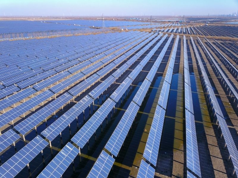 Usina de solo com fileiras de painéis solares para geração de renda.